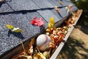 Gutter Rain gutter filled with leaves and a baseball