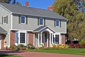 A two story house in the suburbs decorated with pumpkins for Halloween.