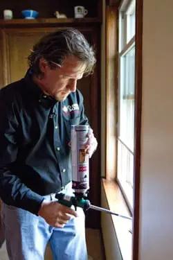 larson & keeney employee air sealing a window