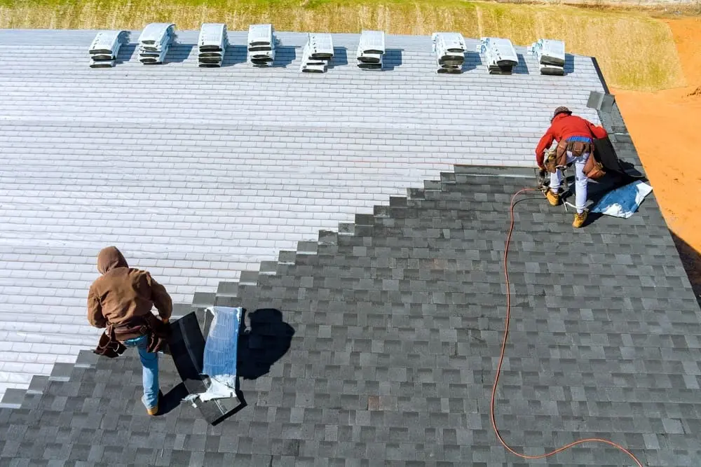 Aerial view of Larson & Keeney Home Services installing bitumen roof shingles with air hammer in Albert Lea