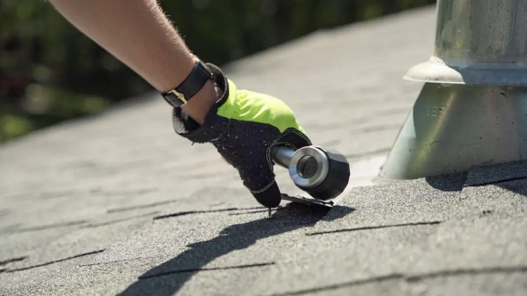 person inspecting an asphalt shingle roof
