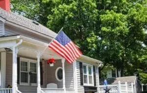 american flag hanging on the porch of a home