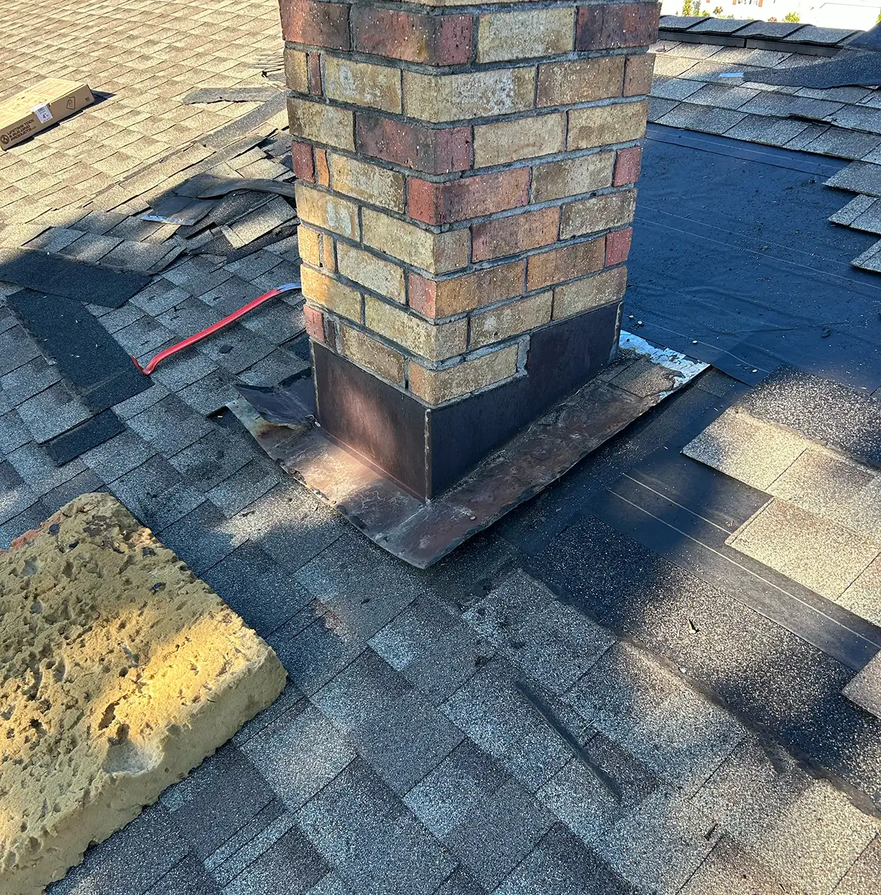 before picture of an old chimney and fallen off asphalt shingles