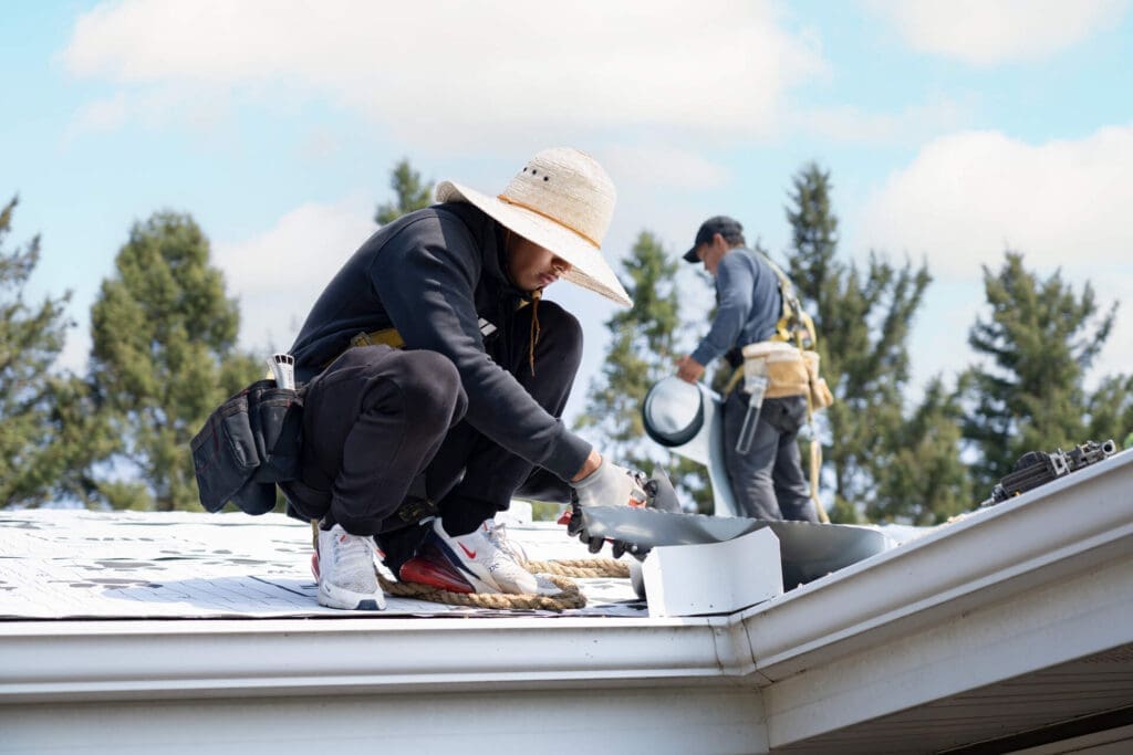 two men on a roof making repairs
