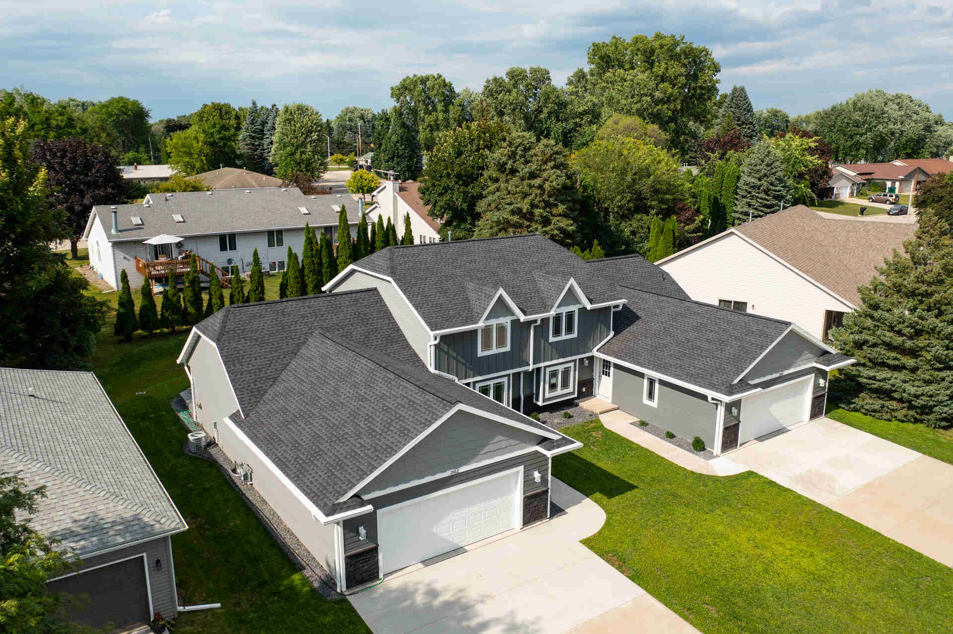 aerial view of a gray house with an asphalt shingle roof