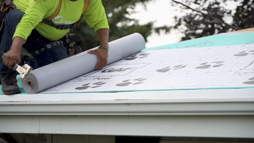 person installing gaf tiger paw synthetic roof flashing
